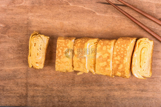 玉上日式煎蛋卷木板上的筷子特图片