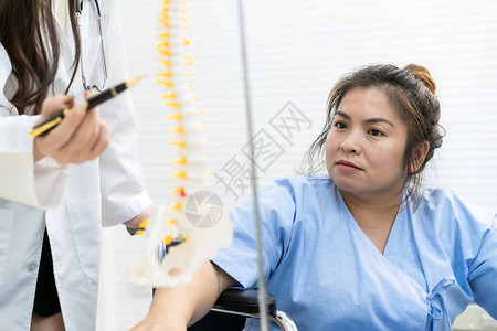 亚洲肥胖女病人在医院与专科医生谈论她的健康问题女人担心她脊椎骨的关键问题超重可能背景图片