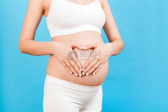 孕妇在婴儿潮中握着双手的心部形状被剪裁成像母亲概图片
