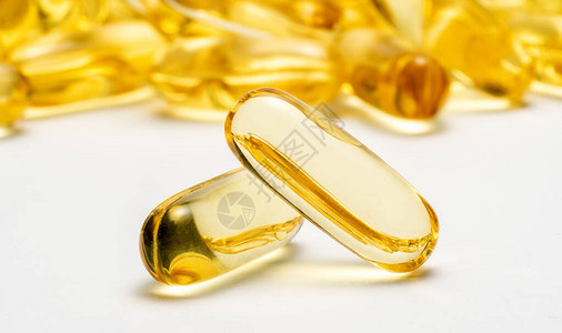 两个Omega3号胶囊和许多其他模糊背景的胶囊医疗图片