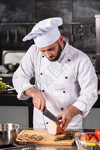 厨师在厨房切肉厨师男切片嗡声在专业厨房在厨房餐厅用刀切嗡图片