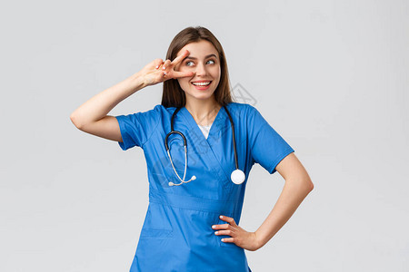 年轻女医生穿蓝洗涤剂的漂亮护士听诊器近视和微笑地展示和平图片