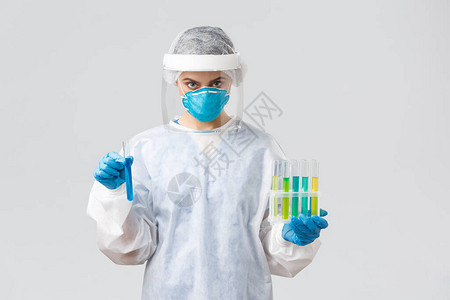 身穿个人防护设备的医生拿着装有冠状疫苗的试管图片
