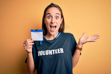 年轻漂亮的女人穿着志愿者T恤做志愿者图片