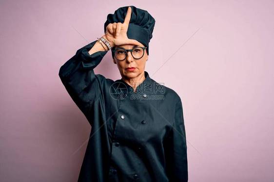 中年黑发女厨师穿着炊具制服和帽子图片