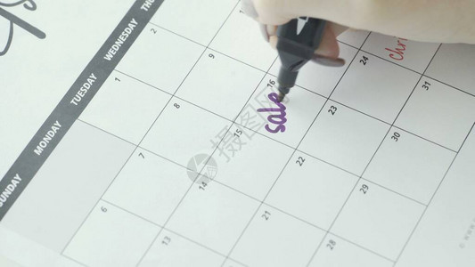 女手写与紫罗兰感觉笔在日历单词SALE图片