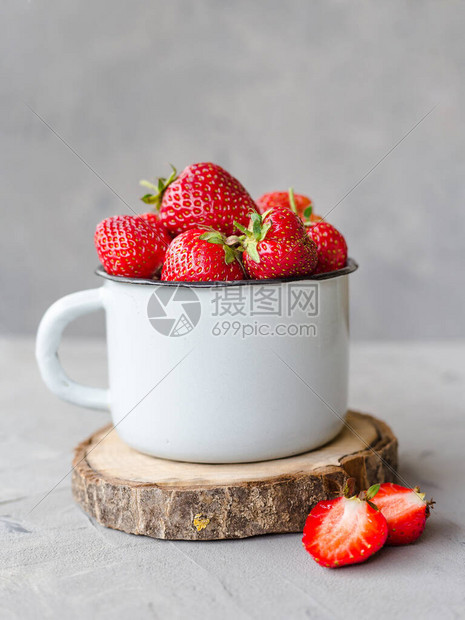 灰色背景的杯子上鲜新美味的草莓图片