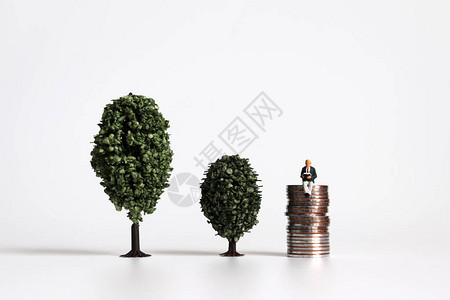 两棵树与一个微型男子并肩坐图片