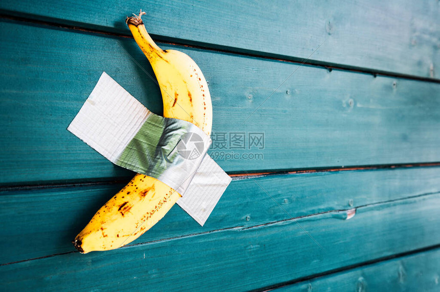 用胶带粘在蓝色木墙上的黄色香蕉管钾和健康生活方式的概念与时令水果维生素和健康人的素食生活方式现代艺术和图片