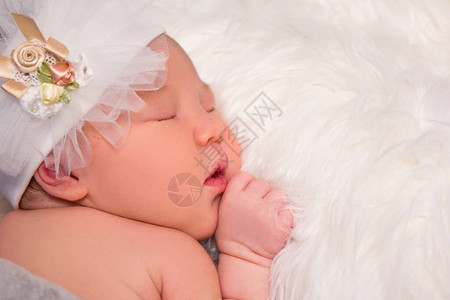 可爱睡着的新生婴儿的肖像和白色毛毯图片