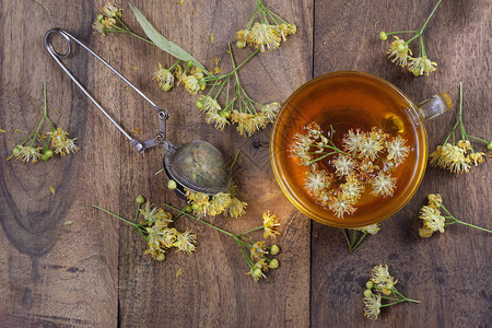 茶和鲜花放在木制桌子上草药茶图片