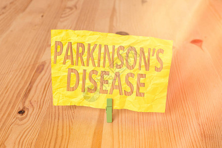 显示帕金森病的概念手写体概念意义晚年慢进行神经系统疾病木地板背景绿色衣图片