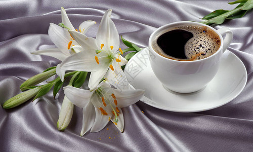 咖啡和白百合花在丝绸背景上浪漫的咖啡图片