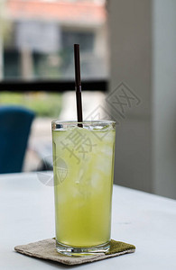 桌上玻璃杯中的冰绿茶背景图片