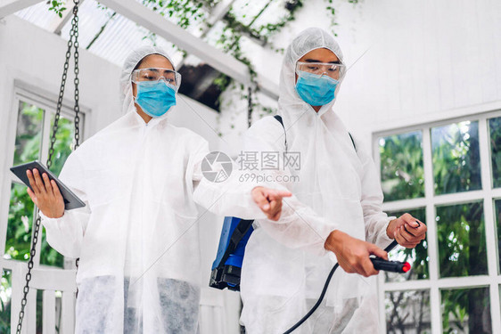 防护面罩消毒人员专业团队和白西服消毒剂喷雾清洁帮助服务在客户家图片