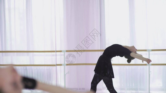 年轻芭蕾舞者在大窗口背景上跳舞背景图片