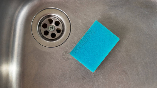 用铁水槽洗碗的蓝色海绵图片