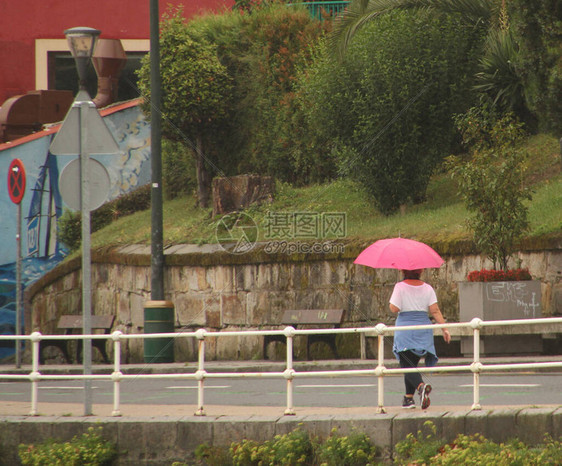 雨中撑伞行走图片