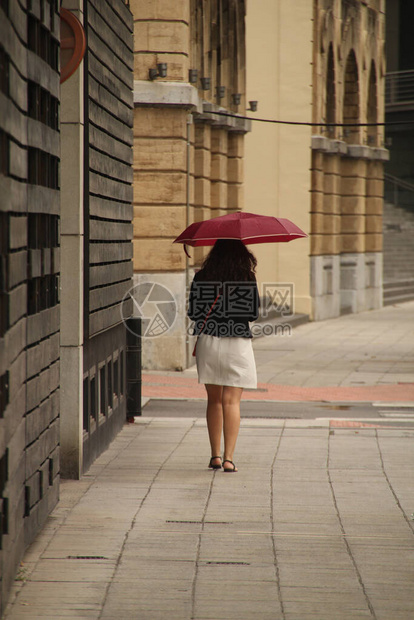 雨中撑伞行走图片