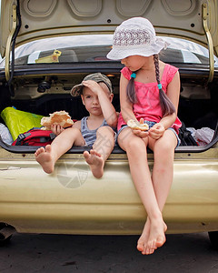 两个兄弟姐妹在家庭公路旅行中休息图片