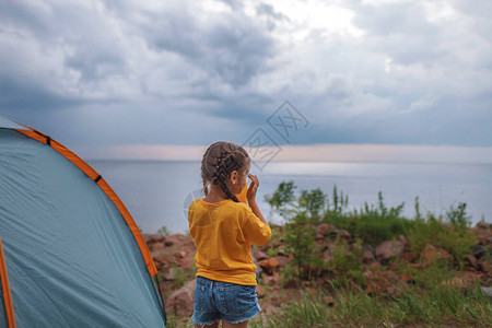 孩子坐在露营地的露营帐篷里图片