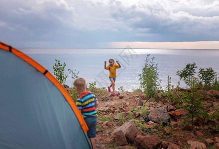 有父亲的孩子在露营地的露营帐篷附近休息图片