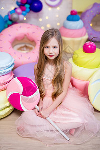 美食概念可爱的小女孩配有巨型糖果图片