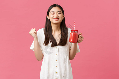 热情开朗微笑的亚洲女用美味的新鲜冰沙增强能量图片