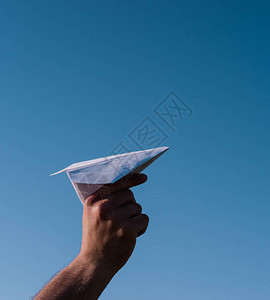 手里拿着纸飞机映衬着蓝天折纸艺术图片