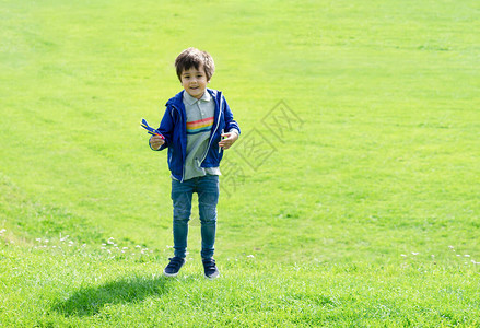 可爱的小男孩在玩塑料飞机玩具图片