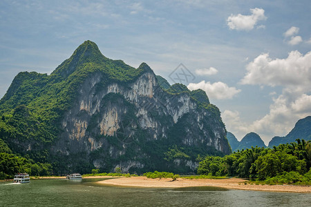 在著名的九马慕拉尔山里程碑峰顶前航行的旅游船图片