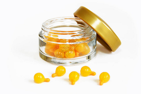 玻璃罐中带有芳香油的橙色胶囊图片素材