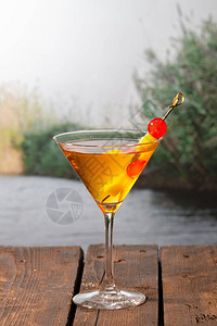 关闭一个美味的鸡尾酒与樱桃和菠萝位串在木桌上的焦点背景上假图片