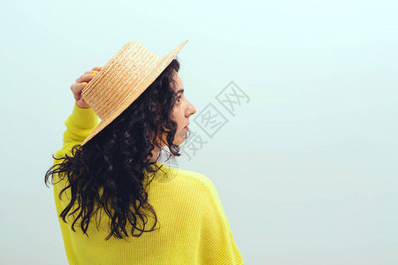 长卷发的黑发女孩漂亮的女人戴着帽子和黄色套头衫美丽和时尚健康的生活方式图片