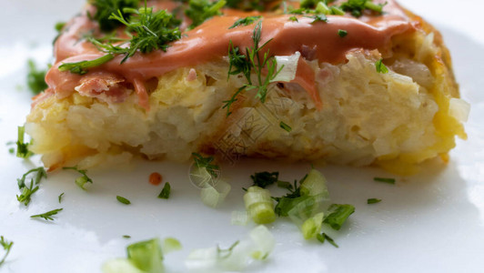 红薯凉粉一块土豆砂锅白盘子里放着酱汁和香草背景