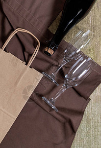 酒瓶眼镜包装袋和木本底包装棕色围裙的盒子图片