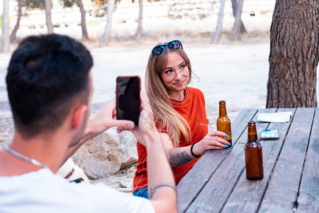 一群朋友在野餐区用智能手机拍照图片