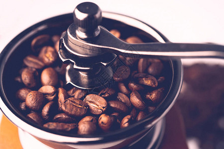 咖啡豆在木制研磨机中烘烤图片