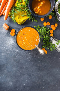 美味的自制奶油胡萝卜汤深灰色桌子上的蔬菜胡萝卜汤泥与新鲜胡图片