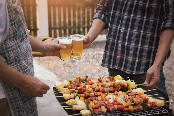 年轻人在BBQ派对上为朋友的饮酒欢呼图片