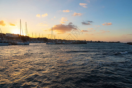 早上日出时在希腊圣托里尼岛上的Vlichada港的船只背景是蓝天图片