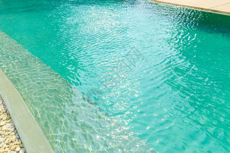 在明亮蓝泳池前关闭石质边界装饰和设计带有阳光反假日放松离家图片