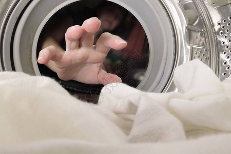 手不熟的女人把衣服放在洗衣机里在洗图片