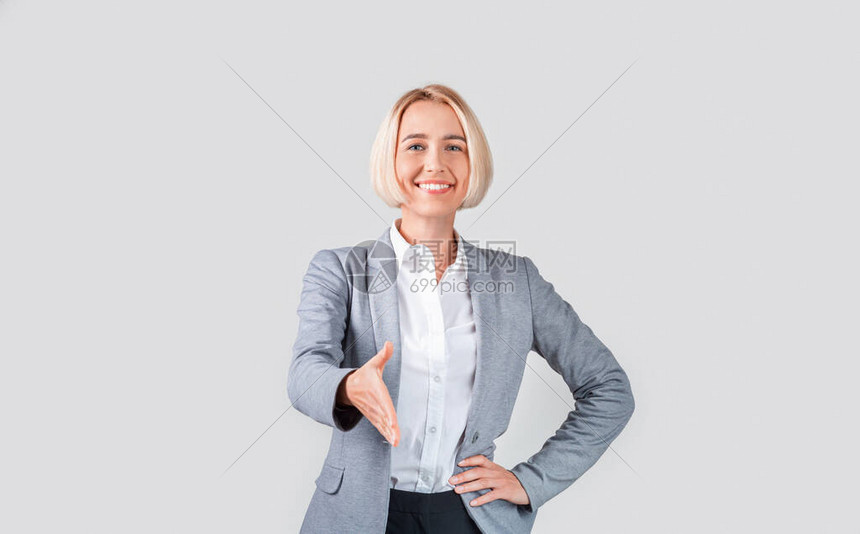 快乐的成熟商业女商人伸出手来握着光工作图片