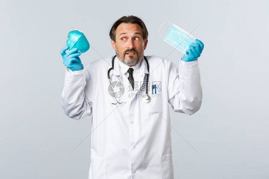 手套和白大衣的无精打采且不果断的医生图片