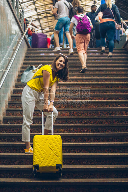 乘坐轮车旅行时妇女用楼梯拉起的重图片