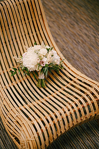 白牡丹玫瑰粉红色洋桔梗落新妇和桉树枝在稻草椅上的新娘花束图片
