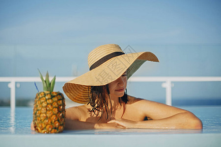 在游泳池里放松暑假女孩在豪华热带度假村的屋顶游泳池享图片