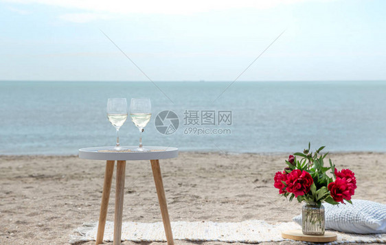 用鲜花和香槟在海边打斗假日的概念图片