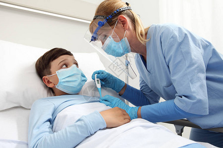 护士用温度计测量病床上病人孩子的发烧图片